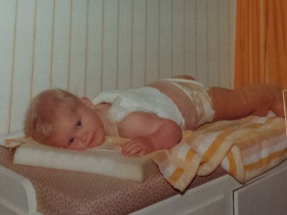 Kind in gipsbroek op kommode