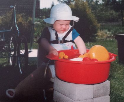 Kind in gipsbroek speelt met water 1