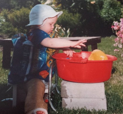 Kind in gipsbroek speelt met water 2